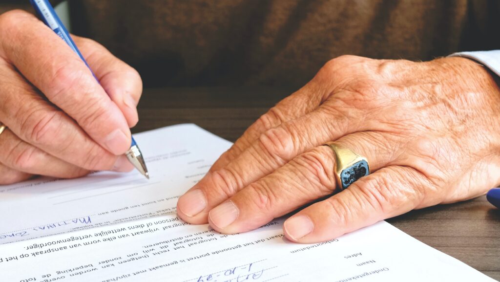 an old man signing a legal document